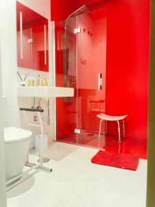 a bathroom with red walls and a glass shower at LAHOLA Glam Suites in Torremolinos +39 photos