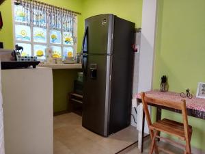 a refrigerator in a kitchen next to a table at Casa Chen-Huaye in Isla Mujeres