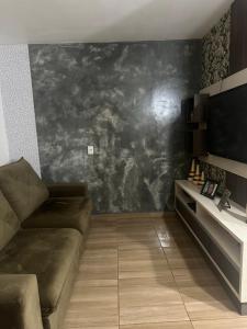 uma sala de estar com um sofá e uma parede preta em Aluga-se casa para Show rural em Cascavel