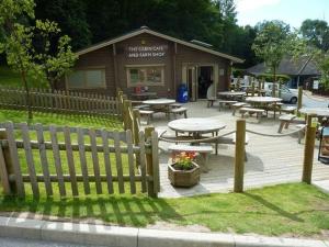 a wooden fence with tables and tables in front of a building at Luke's Lodge in Newton Abbot