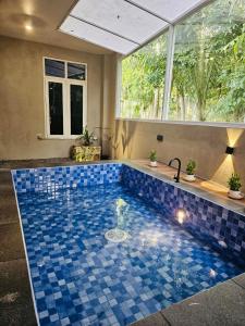 uma piscina com piso em azulejo azul e janelas em Villa Hollandia 
