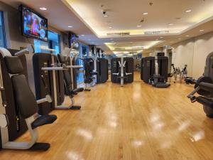 a gym with cardio equipment and a flat screen tv at Downtown Oasis, Burj Khalifa Views, Luxury Amenities in Dubai