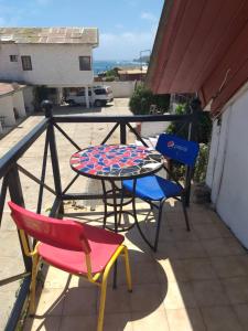 2 sillas, mesa y 2 sillas en el balcón en Hotel Brisas del Quisco, en El Quisco
