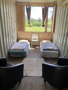 a room with two beds and two chairs and a window at Glamping in Uruguay’s hidden gem in Piriápolis