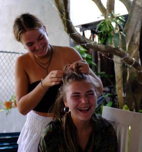 Uma mulher está a cortar o cabelo de uma mulher. em The Lost Hostels, Weligama Beach - Sri Lanka em Weligama