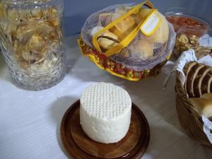 un pastel blanco en una mesa con una cesta de comida en Pousada Castelinho Conservatória, en Conservatória