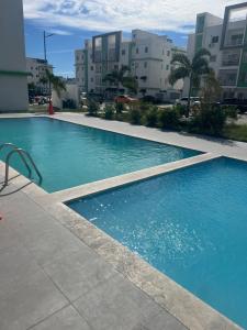 una piscina con acqua blu di fronte agli edifici di Mi casa un sueño entre montañas a Baní