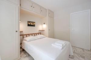 um quarto branco com uma cama branca e armários brancos em Wdf one bedroom heart of Cannes em Cannes