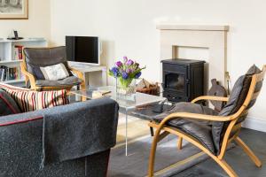 a living room with a couch and a fire place at Manor Coach House in Farrington Gurney
