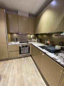 a kitchen with marble counter tops and wooden cabinets at Luxurious 2BD Flat Heart of London Mayfair! in London