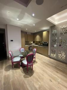 een woonkamer met een tafel en stoelen en een keuken bij Luxurious 2BD Flat Heart of London Mayfair! in Londen