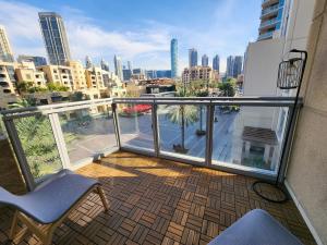 a balcony with a chair and a view of a city at Downtown Oasis, Burj Khalifa Views, Luxury Amenities in Dubai