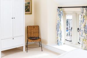 uma cadeira num quarto com uma janela em Manor Coach House em Farrington Gurney