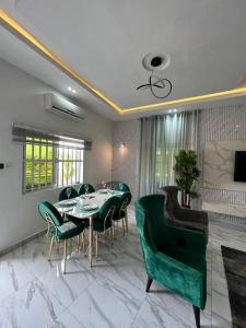 a dining room with a table and green chairs at Djedje Appartement in Cotonou