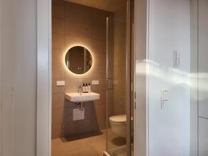 La salle de bains est pourvue d'un lavabo et de toilettes. dans l'établissement SiOUX: stilvolles Designapartment am Bodensee, à Lindau-Bodolz