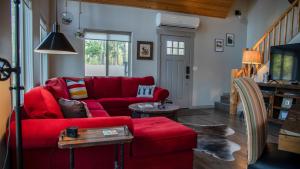 a living room with a red couch and a tv at Elk Street Retreat - Near Glacier Park in Columbia Falls