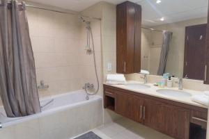a bathroom with two sinks and a tub and a shower at Downtown Oasis, Burj Khalifa Views, Luxury Amenities in Dubai +37 photos