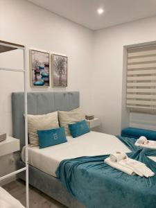 a bedroom with a large bed with blue pillows at Maria Trafaria House in Trafaria