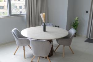 a dining room table with chairs and a vase on it at Downtown Oasis, Burj Khalifa Views, Luxury Amenities in Dubai