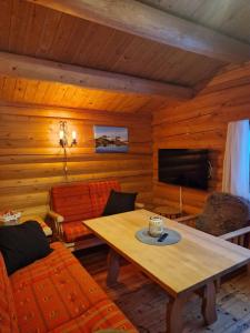 ein Wohnzimmer mit einem Tisch und einem TV in der Unterkunft Weistad in Heidal