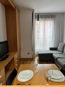 a living room with a table and two wine glasses at Apartamento turístico plenilunio suite, airport, wanda, ifema in Madrid