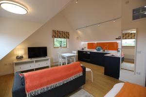 a kitchen and living room with a couch and a table at The Studio Ty Haul in Rhosneigr