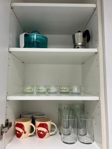 a shelf with cups and other items in a refrigerator at Apartamento turístico plenilunio suite, airport, wanda, ifema in Madrid