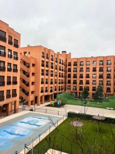 an apartment complex with a large pool in front of buildings at Apartamento turístico plenilunio suite, airport, wanda, ifema in Madrid