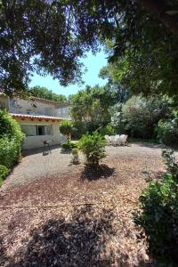 a yard with a bench and a house at L Oustal maison vigneronne in Villeneuve-lès-Béziers