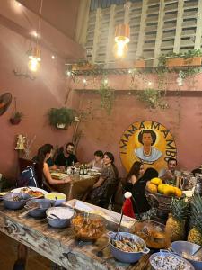 a group of people sitting at a table with food at Hostal Mamamambo in Santo Domingo