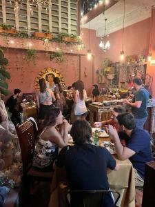 um grupo de pessoas sentadas em mesas em um restaurante em Hostal Mamamambo em Santo Domingo