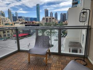 a chair on a balcony with a view of a city at Downtown Oasis, Burj Khalifa Views, Luxury Amenities in Dubai