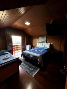 um quarto com 2 camas num chalé de madeira em Pousada da Lua em Campos do Jordão