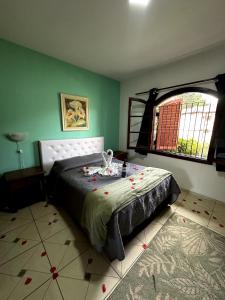 a bedroom with a bed and a large window at Pousada da Lua in Campos do Jordão