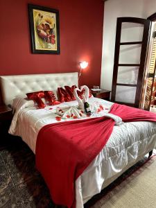 um quarto com uma cama grande com lençóis vermelhos e brancos em Pousada da Lua em Campos do Jordão