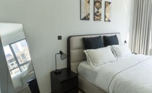 a bedroom with a white bed and a mirror at Downtown Oasis, Burj Khalifa Views, Luxury Amenities in Dubai