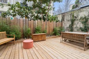une terrasse en bois avec des bancs et une clôture en bois dans l'établissement Large house renovated in Paris - Welkeys, à Paris