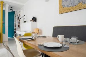 a dining room table with chairs and a wooden table at Large house renovated in Paris - Welkeys in Paris