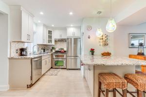 a kitchen with white cabinets and stainless steel appliances at Bright Milford Beach House with Outdoor Shower in Milford