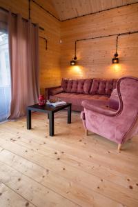 a living room with a pink couch and a table at Domek Na Mazurach in Bogaczewo