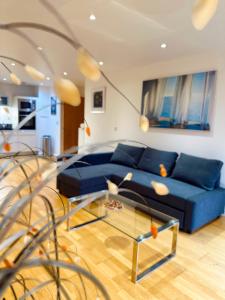 a living room with a blue couch and a glass table at spacious lovely apartment in London