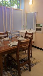 a dining room with a wooden table and chairs at Double A apartment in Ngambo