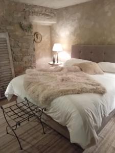 a bedroom with a large bed with a fur blanket at Le Lodge des Flâneurs in Vielsalm