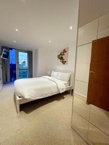 a white bedroom with a bed and a glass closet at spacious lovely apartment in London