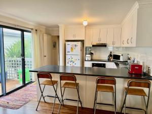 a kitchen with a black counter top and chairs at Clampetts Pet Friendly Close to Township in Robe