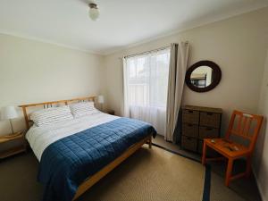 a bedroom with a bed and a mirror and a chair at Clampetts Pet Friendly Close to Township in Robe