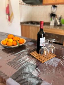 una bottiglia di vino su un bancone con un piatto di arance di Chalet Rutas de Valsequillo a Valsequillo