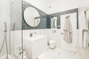a bathroom with a toilet and a sink and a mirror at Striking & Modern 2BD Flat wGarden - East Dulwich in London