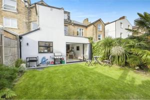 an exterior view of a house with a yard at Striking & Modern 2BD Flat wGarden - East Dulwich in London