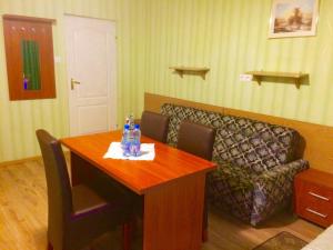 a living room with a table and a couch at Hotel i Restauracja Sara in Polanica-Zdrój